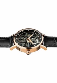 Skelettklocka med svart läderrem, roséguld case, transparent urtavla som visar upp intrikata mekanismer och rund form.