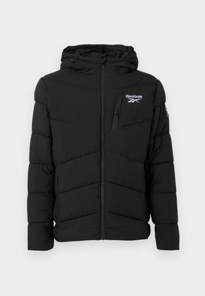 Čierna prešívaná bunda s kapucňou, ktorá má šikmý prešiv, zips vpredu a logo Reebok na hrudi a rukáve.