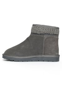 Bota gris de ante con un puño superior de punto. Presenta una suela plana y una punta redonda. Superficie texturizada y detalles de costura sutiles.