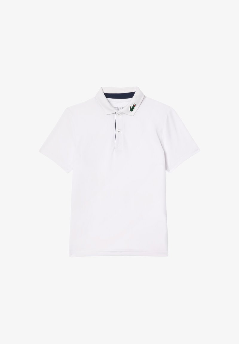 Valkoinen polo-paita, jossa on ribbitetty kaulus, jossa on laivastonsinisiä yksityiskohtia ja vihreä brodeerattu logo vasemmalla puolella. Lyhyet hihat, puuvillamateriaali.