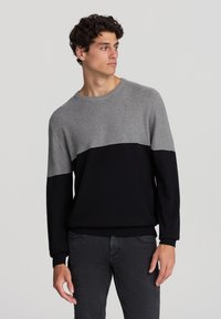 Sweter dzianinowy z szarym górnym częścią i czarną doln�ą częścią. Okrągły dekolt, długie rękawy oraz ściągacze przy mankietach i u dołu.