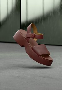 Μπορντό σανδάλι πλατφόρμα με φαρδιές λουρίδες, ρυθμιζόμενο αγκράφα στον αστράγαλο, υφή από λείο δέρμα και καμπυλωτό σχέδιο σόλας.