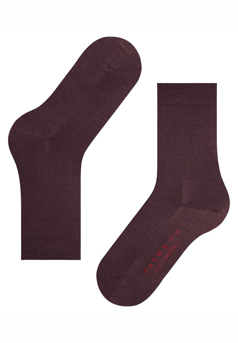 Paar dunkelbraune Knöchelsocken mit gerippten Bündchen, eine Socke liegt flach, die andere mit der Sohle nach oben, auf der rote Schrift auf weißem Hintergrund zu sehen ist.