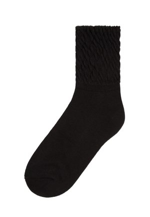 Schwarze Socke mit einem strukturierten Zopfmuster am Bündchen, aus weichem Material gefertigt, mit einem glatten Körper und einer runden Zehe.