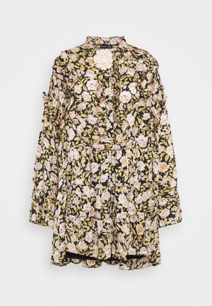 Vestido floral negro con diseño de volantes, con flores en tonos pastel rosa y amarillo, cuello alto y mangas largas. Tejido texturizado con capas en volantes.