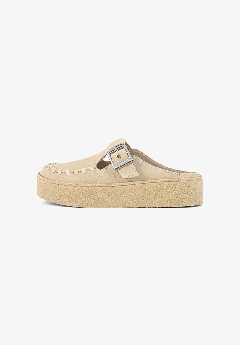 Beige mockasins i suede med ett vävt mönster vid tån, upphöjd platåsål och en silverfärgad spänne som accent på ovansidan.