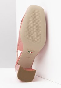 Pink patent leather shoe with a curved heel, textured beige sole, and cut-out side detailing. Marked "NeroGiardini" and size 37.