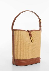 Vaaleanruskea punottu olkakori, jossa on ruskea nahkapohja ja -olkahihna. Varustettu kullalla soljella ja sileällä pinnalla.