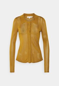 Långärmad skjorta i senapsgul med knappar, mjuk ribbad textur, figursydd passform och spetsig krage. Fem knappar framtill.