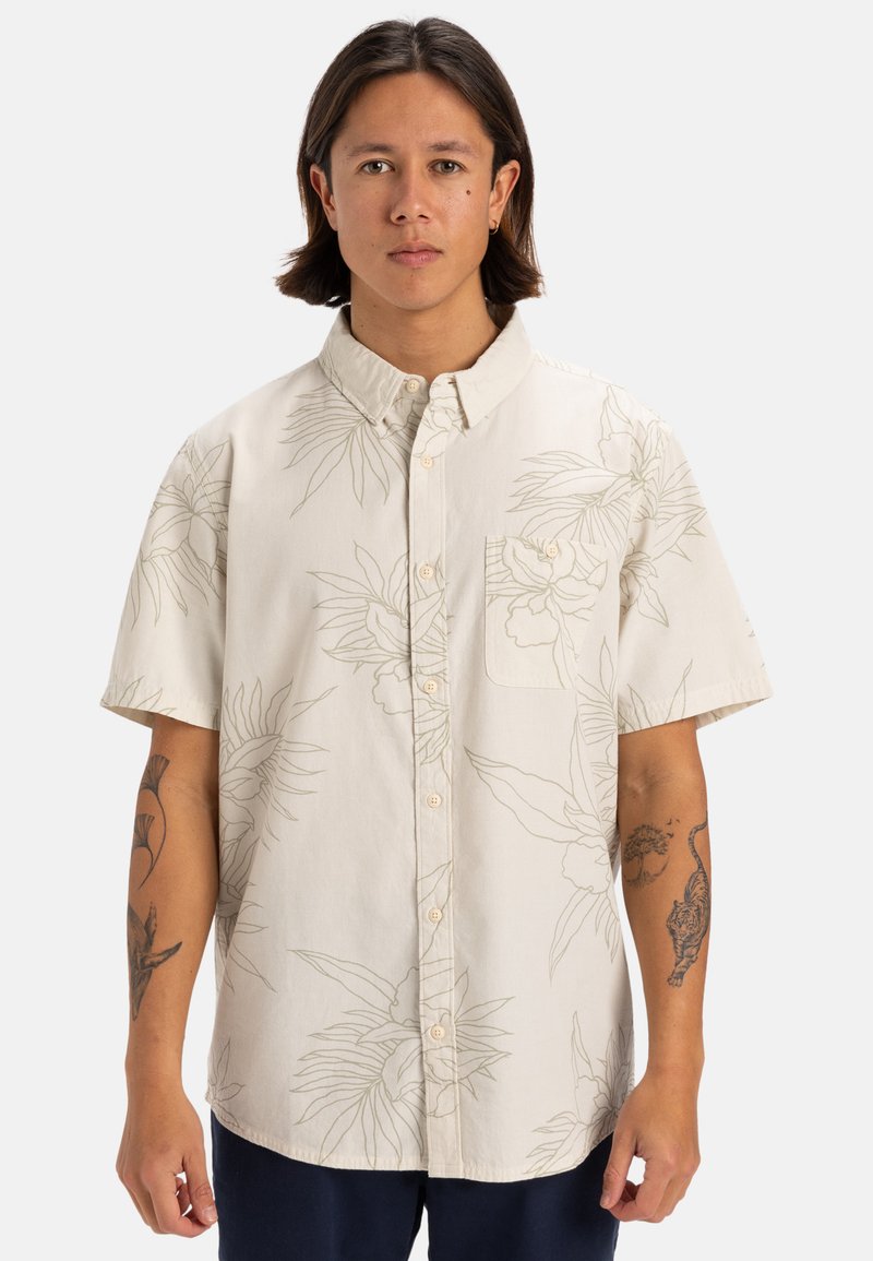 Camicia a maniche corte in crema con un motivo a contorni botanici, chiusura a bottoni e taschino sul petto. Realizzata in tessuto leggero.