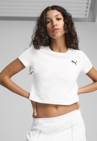 Biała krótka koszulka z bawełny z okrągłym dekoltem i krótkimi rękawami. Posiada małe czarne logo Puma na lewej stronie klatki piersiowej.