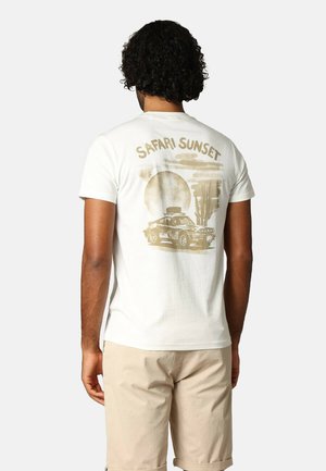 Witte T-shirt met korte mouwen, voorzien van een grafisch ontwerp van een auto tegen een zonsopgang achtergrond, met de tekst "Safari Sunset" erboven.