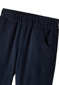 Pantalon en velours côtelé bleu marine avec une taille élastique, deux poches latérales et des rainures verticales sur le tissu, mettant en valeur une surface texturée.