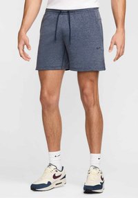 Pantalones cortos deportivos azul marino hechos de material suave, con una cintura ajustable con cordón y bolsillos laterales. Pequeño logotipo en la pierna izquierda.