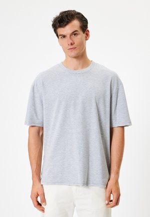 Grå bomulds t-shirt med rund hals, korte ærmer og en afslappet pasform. Blød tekstur med et diskret meleret mønster.
