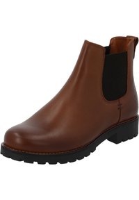 Bota Chelsea de piel marrón con paneles laterales elásticos negros, punta redondeada y suela de goma duradera con un patrón de tracción texturizado.