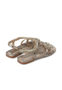 Platte sandalen met metallic gouden banden, versierd met heldere edelsteenachtige accenten, met een platte zool en een open ontwerp.
