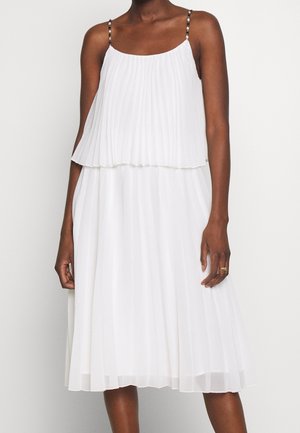 Vestito bianco plissettato con tessuto a strati, spalline con un motivo sottile e gonna fluente che arriva sotto il ginocchio.