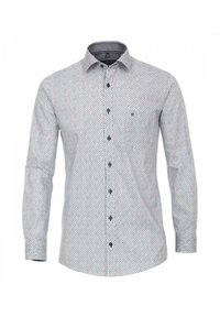 Vit långärmad skjorta med knappar, prydd med små blåa och röda geometriska mönster och mörka knappar. Den har en spridd krage och åtsittande manschetter.