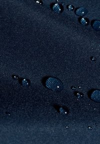 Marinblått textil med vattendroppar på ytan, som visar en glansig finish och ett detaljerat vävmönster.