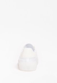 Baskets blanches avec un talon transparent ; empeigne lisse, col rembourré et laçage à l'avant ; dotées d'une semelle en caoutchouc solide et d'un design minimaliste.