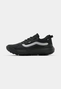 Sorte Vans sneakers har et elegant design med en strukturert overflate, reflekterende sølvdetaljer og en robust såle med mønster for godt grep.