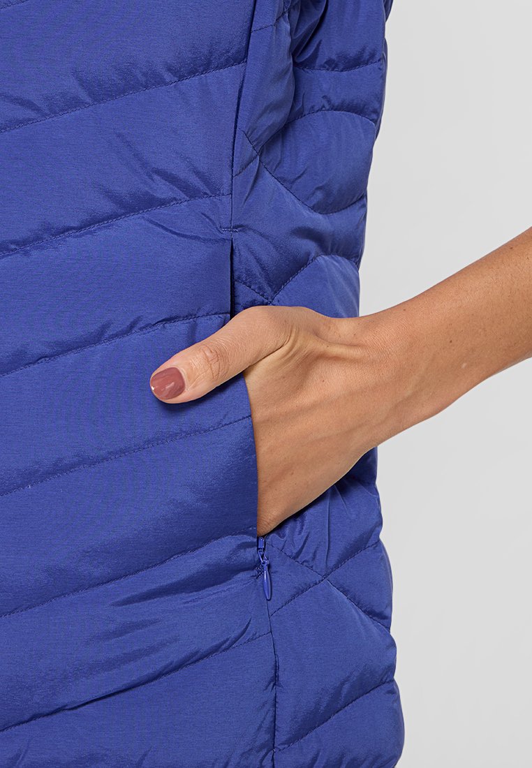 Blauer gepolsterter Weste mit geometrischem Steppmuster, ausgestattet mit einer seitlichen Reißverschlusstasche. Hergestellt aus leichtem, glattem Stoff.