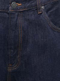 Jean en denim bleu foncé en gros plan montrant la poche avant, les coutures orange et le bouton métallique avec le texte "ONLY & SONS".