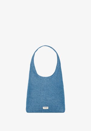 Sac à épaule en denim bleu avec une poignée incurvée et une forme rectangulaire. Présente une étiquette à l'avant. Texture lisse, design minimaliste.
