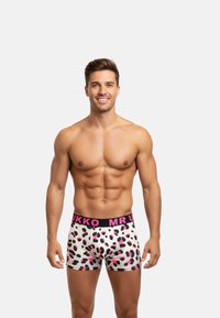 Boxer pour homme avec une base blanche, un imprimé léopard rose et noir, et une ceinture noire contrastante portant le texte "MR U" en rose.