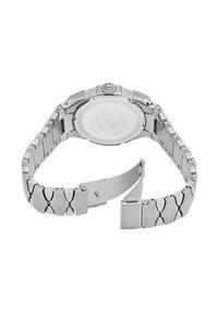 Silverfärgad klocka i rostfritt stål med en polerad metalrem och ett runt boett. Har en strukturerad krona och en slät, genomskinlig baksida.