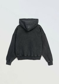 Czarna hoodie z luźnym krojem, ze ściagaczami na rękawach i u dołu. Materiał wydaje się miękki z delikatną fakturą. Brak widocznych logo lub wzorów.