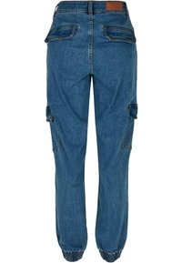 Pantalon cargo en denim bleu avec poignets élastiqués, deux poches à rabat au dos et poches cargo latérales, vu de dos.