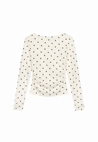 Langsleeve top in crèmekleurige stof met een geplooide zijkant, voorzien van een patroon van kleine bruine stippen. Gladde, lichtgewicht textuur.