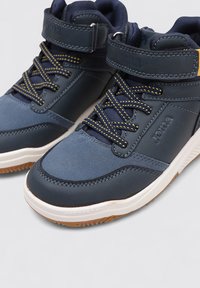 Zapatillas altas azules con parte superior de cuero texturizado y malla, cordones con acentos en amarillo y una suela de goma blanca. Presenta una correa ajustable.