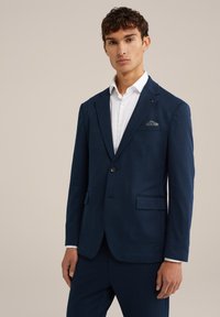Giacca di suit blu navy con texture, colletto a revers e chiusura con un solo bottone, dotata di un fazzoletto da taschino con un motivo decorativo.