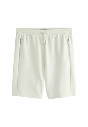 Bílé šortky ke kolenům s elastickým pasem, stahovací šňůrkou a dvěma vertikálními kapsami na zip na předních stranách.