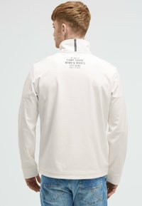 Giacca leggera bianca con colletto alto, caratterizzata da un logo stampato sulla schiena. Tessuto morbido e maniche lunghe. Vestibilità casual.