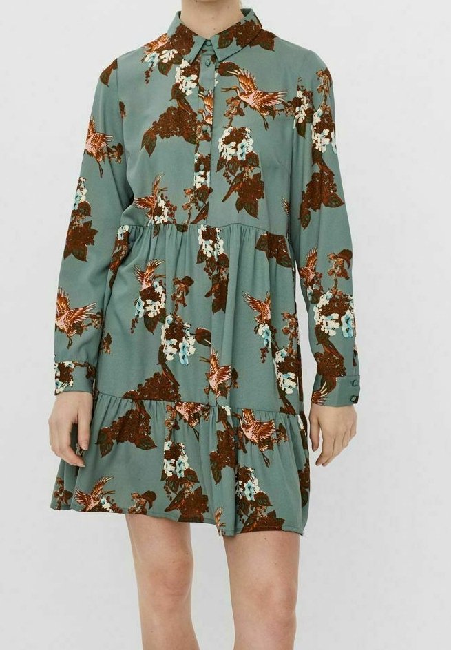 Robe à manches longues de couleur bleu sarcelle avec col, ornée de motifs floraux et d'oiseaux marron et blancs, boutonnée à l'avant et évasée au niveau de la jupe.