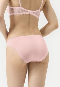 Rosa bomullstrosor med en slät textur. Designen har minimal styling och inga synliga sömmar för en sömlös look.