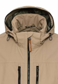 Beige waterdichte jas met een gevoerde capuchon, een rits aan de voorkant en twee ritszakken, met zwarte accenten en een gestructureerde stof.