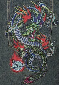 Vyšívaný design draka na tmavém denimu, zdobený živými barvami, plameny a složitými šupinami, s podrobnými vířivými vzory a akcenty.