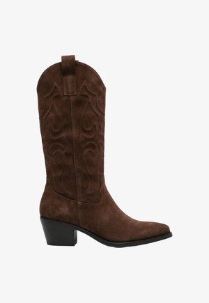 Botte de cowboy en daim marron avec coutures décoratives, hauteur mi-mollet, bout pointu, languette de tirage et talon bloc empilé.