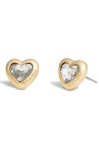 Boucles d'oreilles en forme de cœur en ton or avec un centre en pierre facettée transparente ; présente l'inscription "COACH" gravée sur un côté. Finition lisse, surface polie.