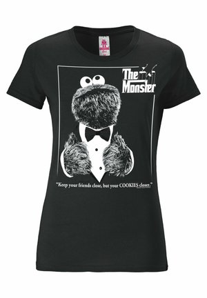 Black cotton t-shirt featuring a printed graphic of a monster in a tuxedo, with the text: "The Monster" and a quote about cookies.