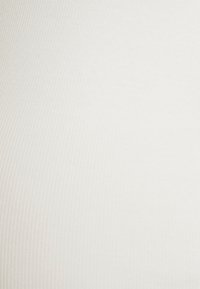 Textura de tecido branco com nervuras, suave e com linhas verticais, apresentando uma qualidade macia e elástica, exibindo um design liso sem padrões.