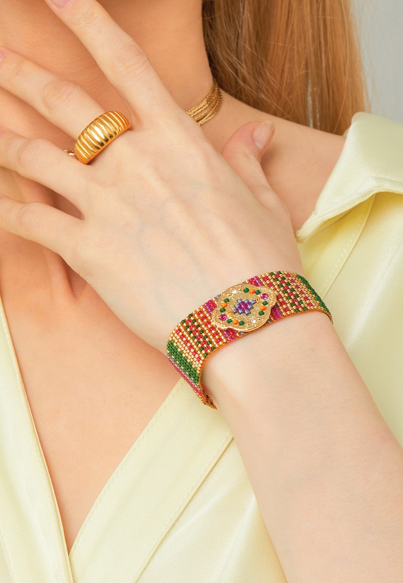 Colorful beaded bracelet with green, pink, and gold patterns, featuring a decorative gold clasp with multicolored accents.