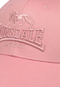 Rózsaszín pamut baseball sapka, texturált felülettel, hímzett oroszlán logóval és a "Lonsdale London" felirattal az elején.