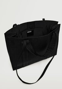 Czarna torba na ramię z wydłużonymi uchwytami, wykonana z trwałego materiału. Wnętrze z kieszenią na zamek; elegancki, minimalistyczny design z subtelnymi akcentami.