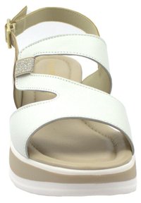 Sandal bianco con più cinturini larghi, una suola imbottita color beige chiaro e un elemento decorativo in argento sulla cinghia frontale.